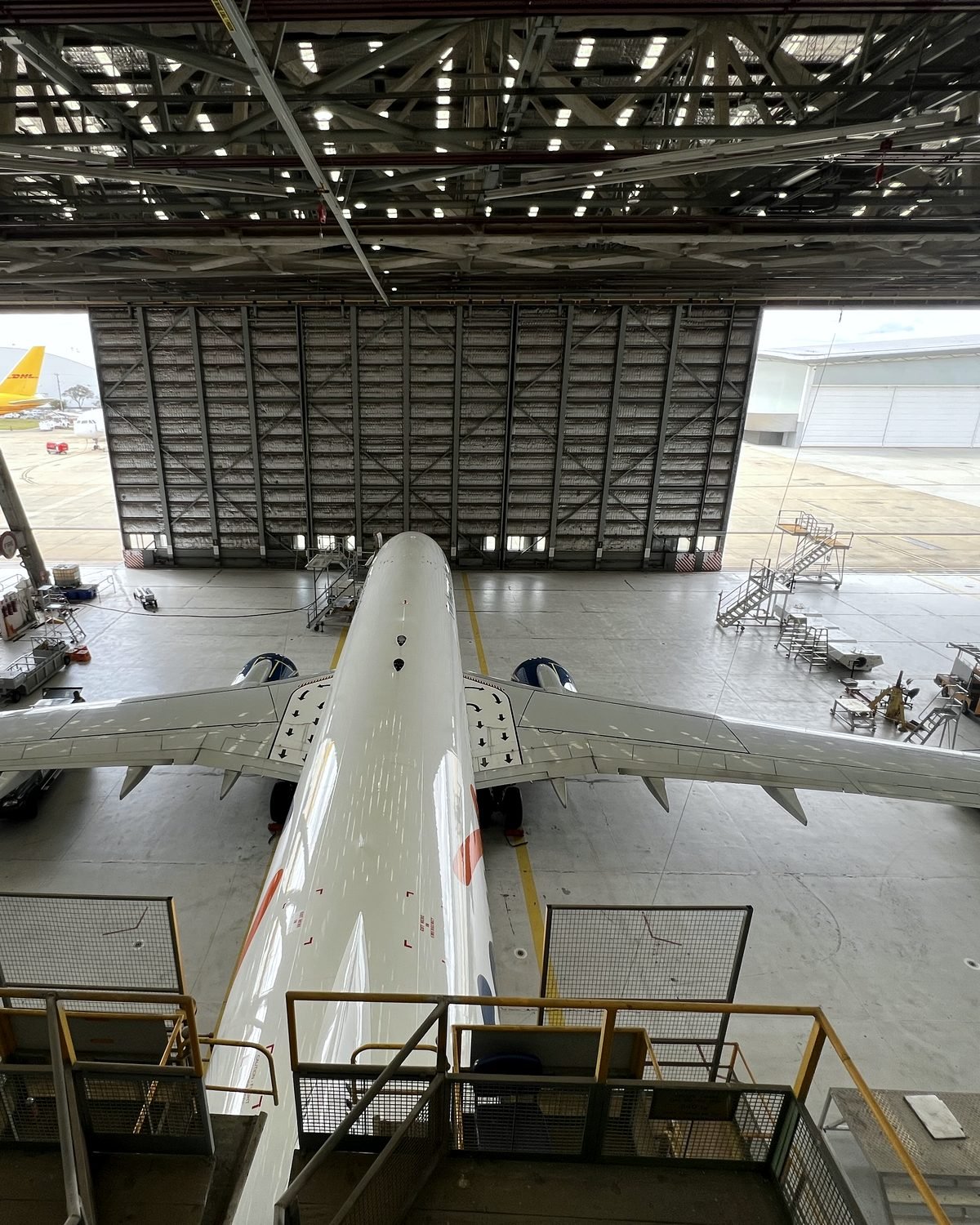 Looking down the fuselage from the hangar mezzanine, doors open to the apron